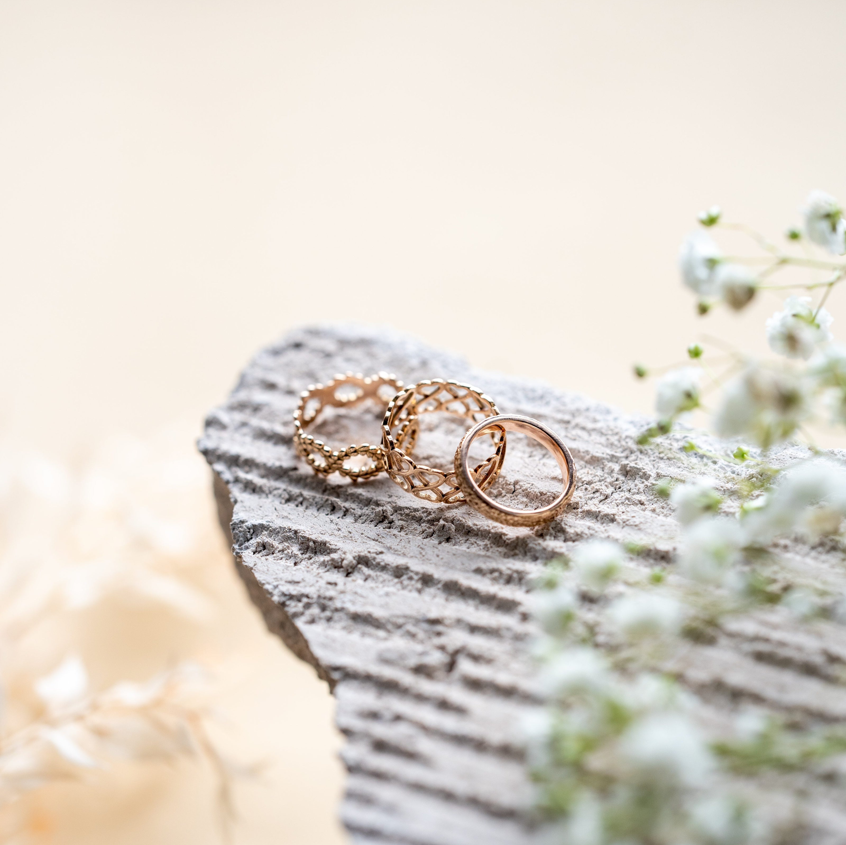 Love rings sitting on a grey stone.