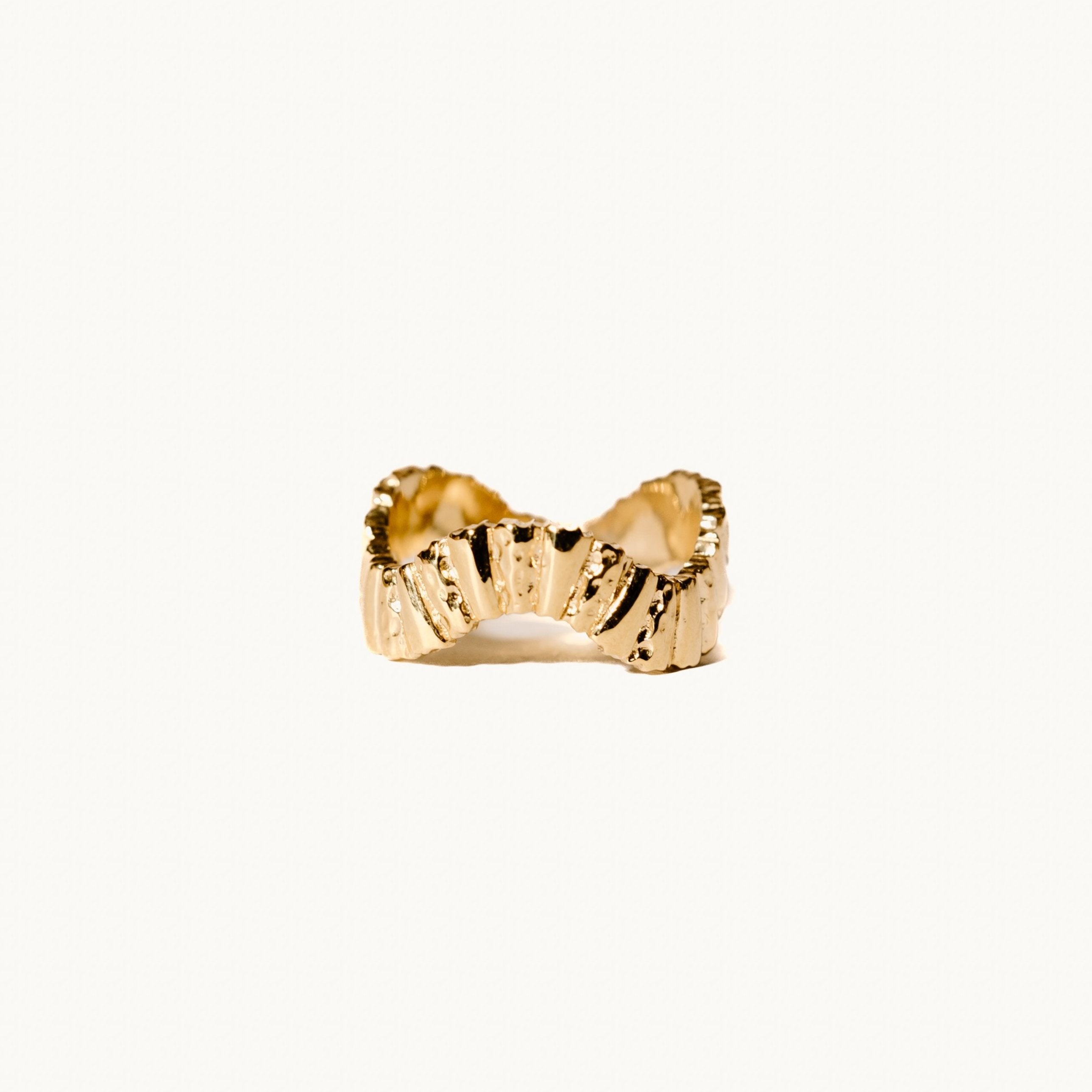 Unique gold ring on white background.